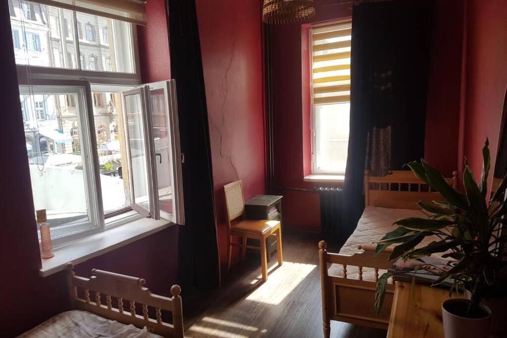 een slaapkamer met rode muren en een bed en een raam bij 2 room apartment in the Heart of Old Riga in Rīga