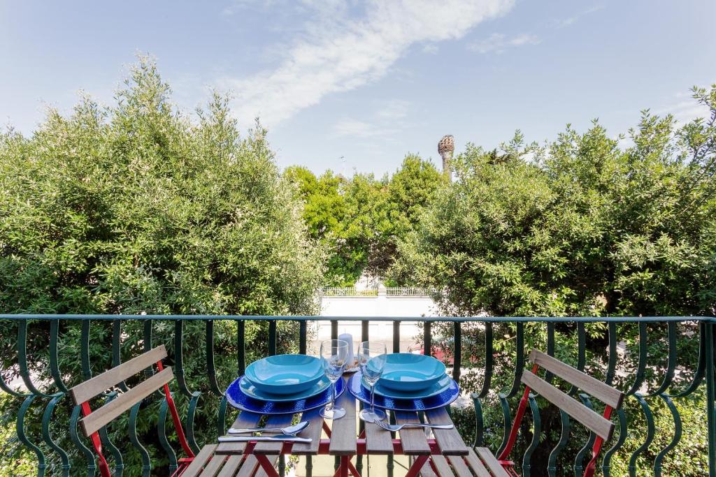 einem Tisch mit zwei Stühlen und blauen Platten darauf in der Unterkunft Casa Ginevra - 3 Minutes Walk from the Sea in Livorno