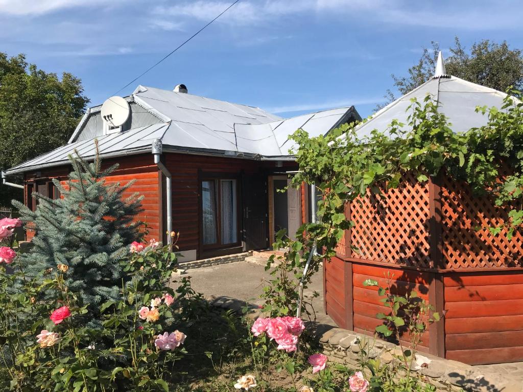 a house with a fence and flowers in the yard at Прикарпаття in Kosiv