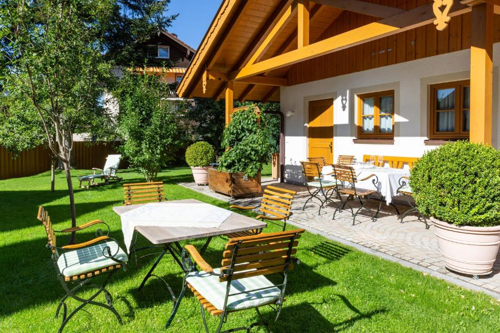 a patio with a table and chairs on the grass at Landhaus Theresa in Bad Tölz