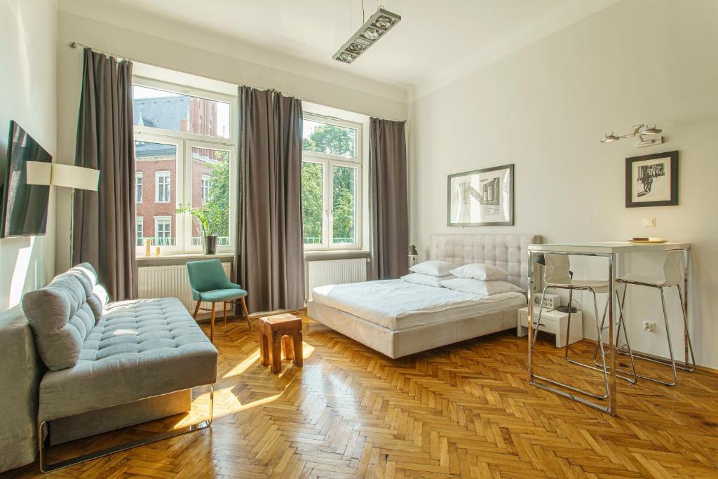 a bedroom with a bed and a couch and a table at NOVUMHOUSE - Straszewskiego in Kraków