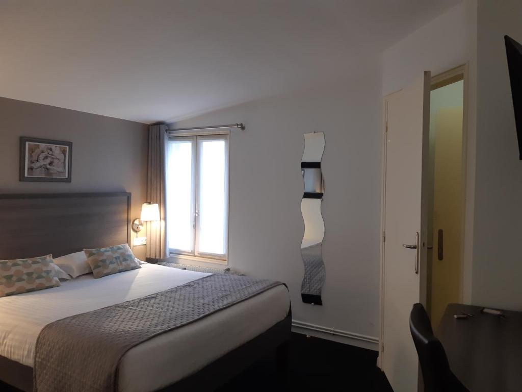 a bedroom with a large bed and a window at Aerotel Versailles Saint Cyr - L'étape du Silence in Saint-Cyr-lʼÉcole