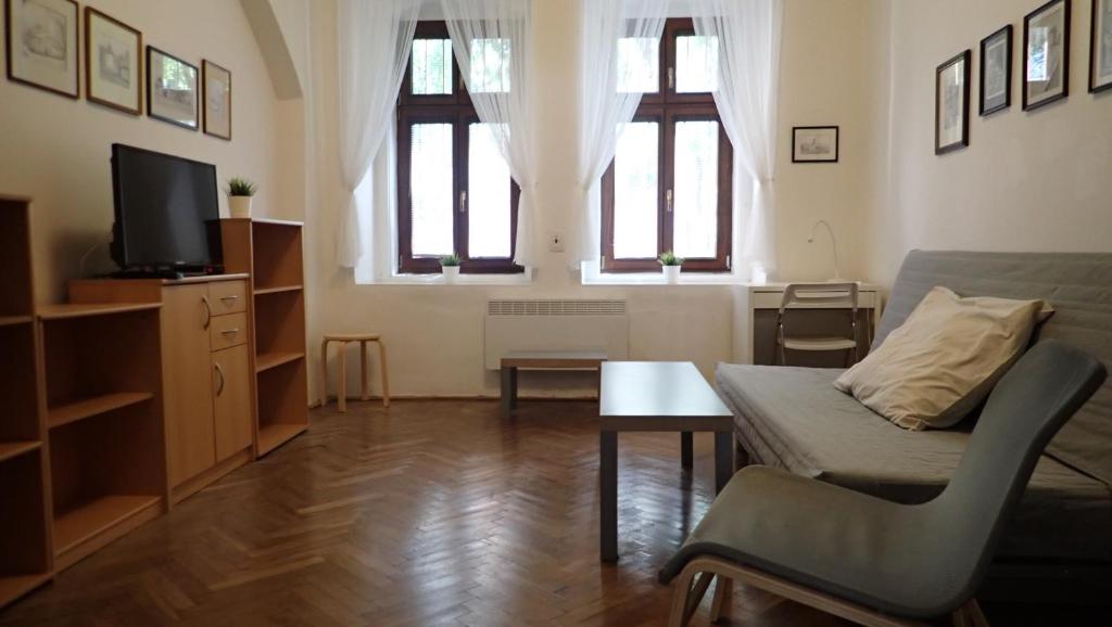 - un salon avec un canapé et une télévision dans l'établissement Apartment Jackie, à Prague