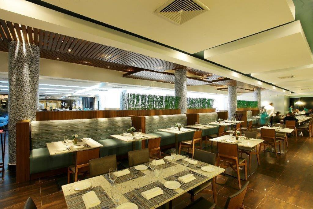 Un comedor con mesas y sillas en un restaurante. en Hotel Mykonos, en Santiago de Veraguas