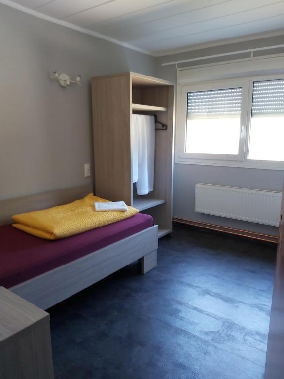 um pequeno quarto com uma cama e uma janela em Motel-Stuhr em Stuhr
