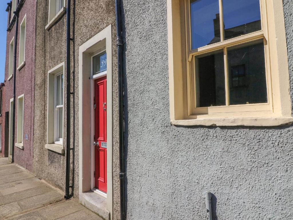 una puerta roja y ventanas en un edificio en Number Thirty-Nine, en Ulverston
