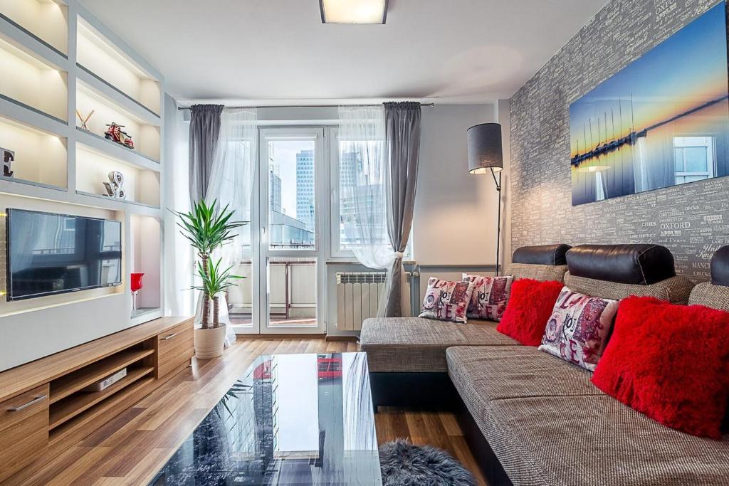 uma sala de estar com um sofá e uma televisão em L Rent like home - Panska 3 em Varsóvia