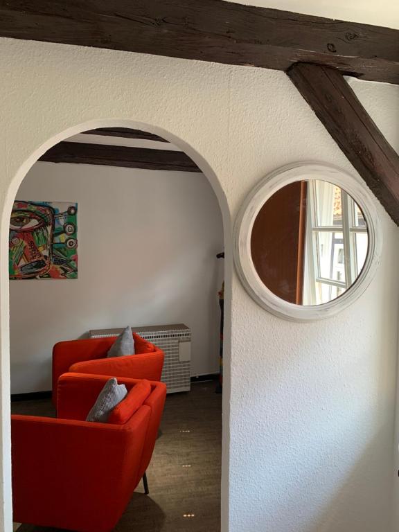 uma sala de estar com duas cadeiras vermelhas e uma janela em Ackerbürgerhaus von 1604 em Goslar