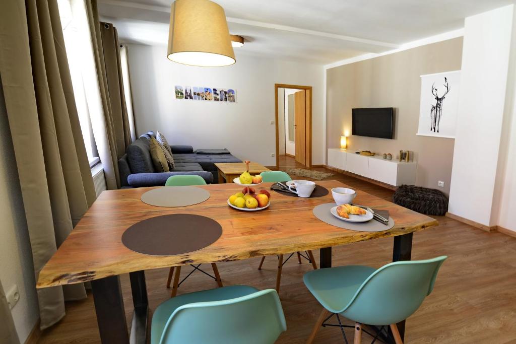 sala de estar con mesa de madera y sillas azules en Pretti Apartments - NEUE moderne Wohnung im Herzen Bambergs - absolut zentral, en Bamberg