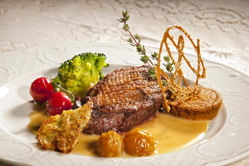 une assiette de nourriture avec un steak et des légumes dans l'établissement Château des Monthairons Hôtel Restaurant GastroMaison Spa privatif, à Les Monthairons