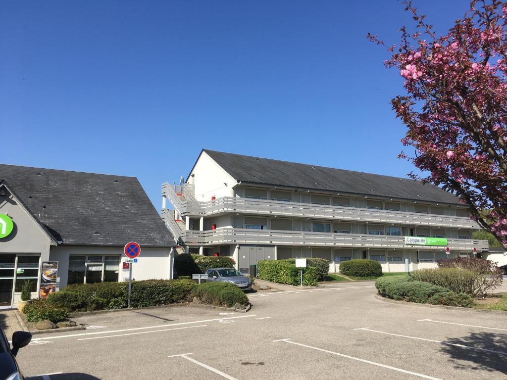 an empty parking lot in front of a building at Campanile Saint-Etienne Est- Saint-Chamond in Saint-Chamond