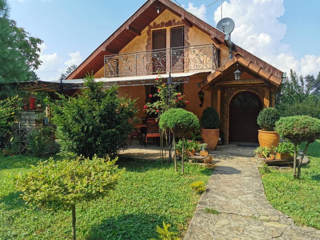 a house with a balcony and a yard at Vikendica kraj Dunava Oaza in Banoštor