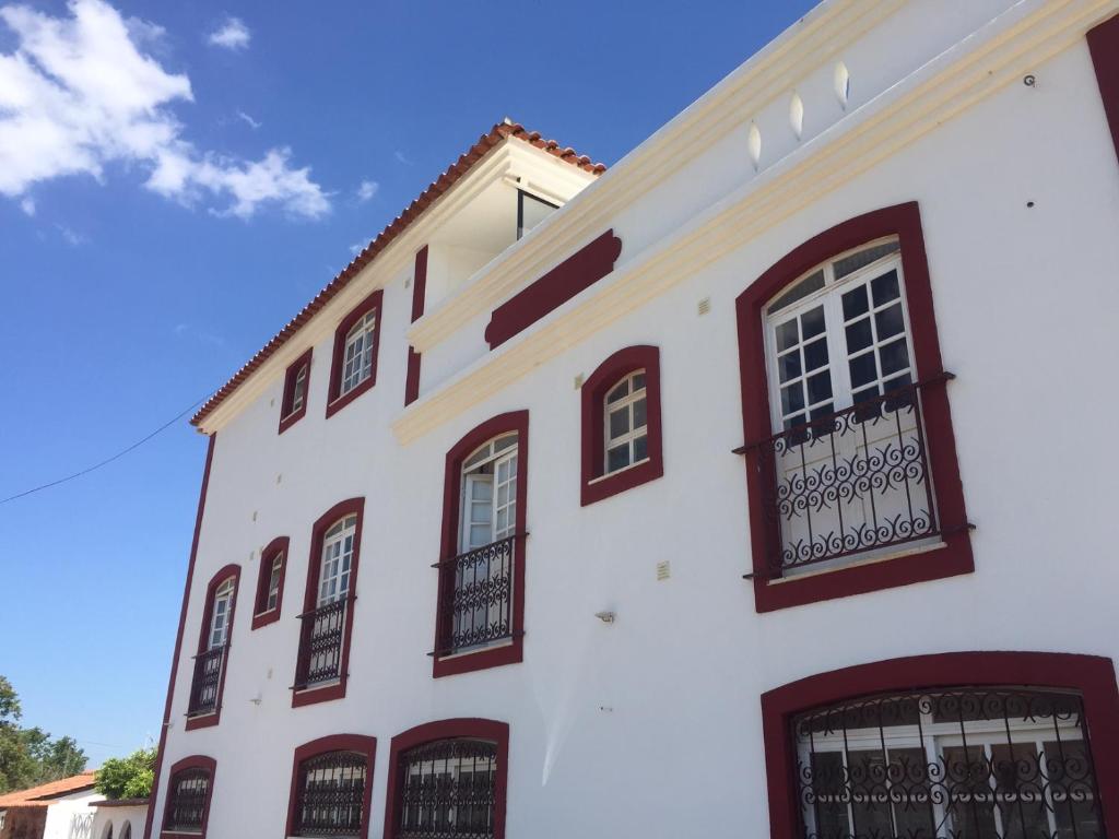 a white building with black windows and a blue sky at Ponte Romana in Silves