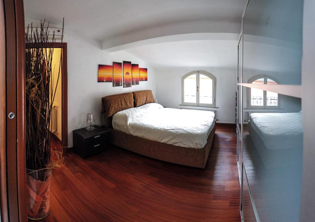 a bedroom with a large bed and a glass door at STUPENDA MANSARDA CENTRALISSIMA, finiture di lusso in Carrara