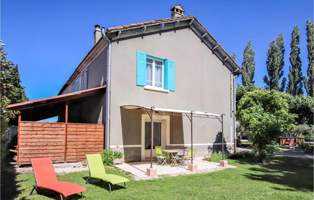 uma casa com cadeiras coloridas no quintal em Awesome Home In Verquires With 3 Bedrooms, Wifi And Outdoor Swimming Pool em Verquières