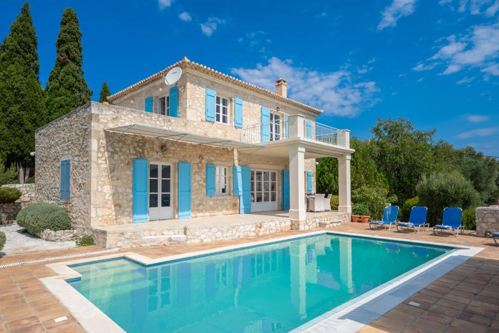 a villa with a swimming pool in front of a house at Villa Pelagos in Tselendáta