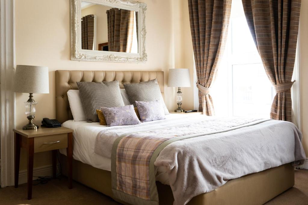 a bedroom with a bed with a mirror and a window at Brogans Bar & Hotel in Trim