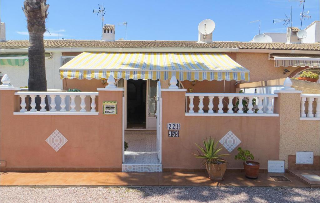 a house with a porch with a striped awning at Pet Friendly Home In Torrevieja With Kitchen in Torrevieja