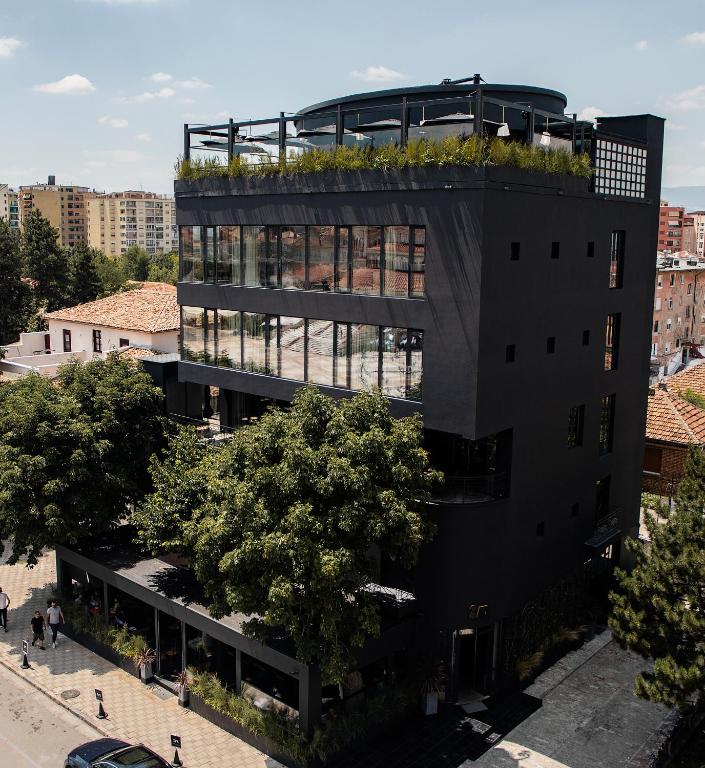 um edifício de escritórios com um jardim no último piso em cima em IN Gallery Hotel & Spa em Korçë