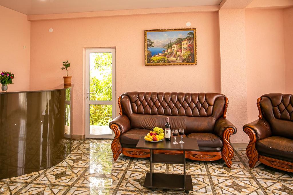 a living room with two leather couches and a table at SanZazila in Gudauta