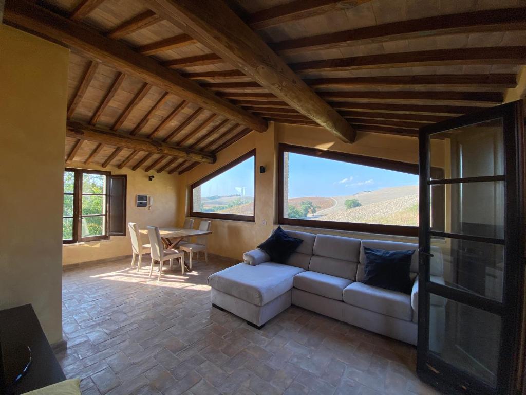 a living room with a couch and a table at Tuscany Charme Boutique House in Monteroni dʼArbia