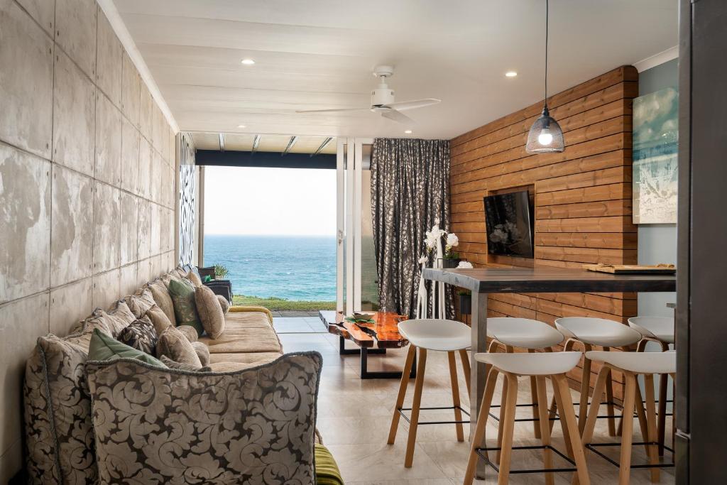 a living room with a couch and a table at Sea front designer apartment in Ballito