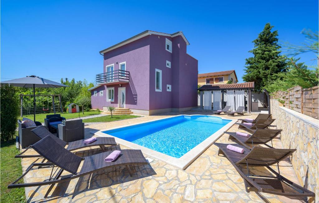 a swimming pool with chairs and a house at Beautiful Home In Perci With Outdoor Swimming Pool in Tar