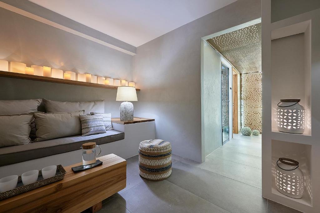 a bedroom with a bed and a table and a chair at Santa Maria Luxury Suites & Spa in Adamas