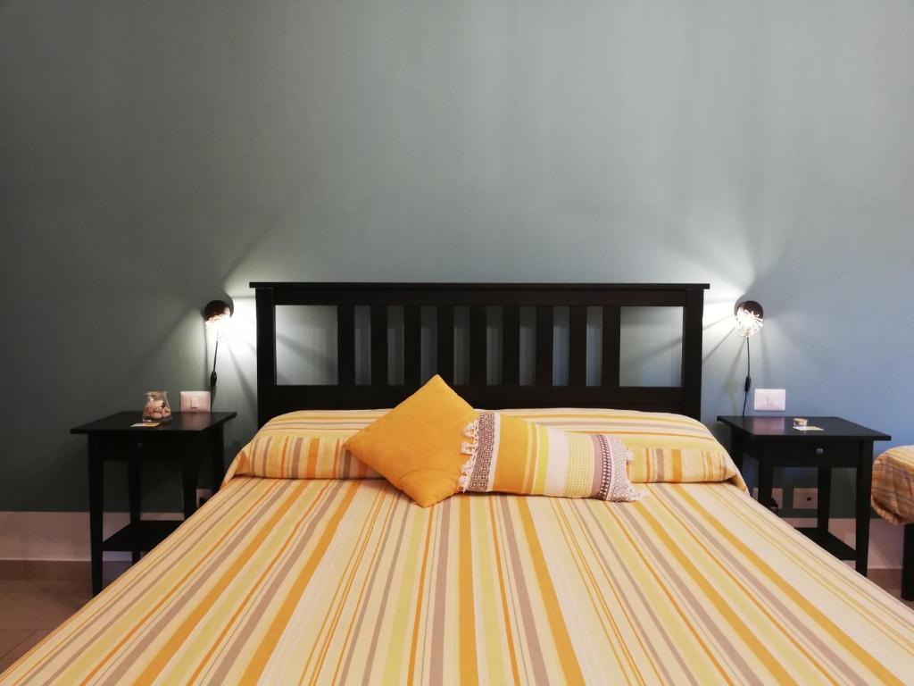 a bedroom with a large bed with two night stands at The Yellow House in Fiumicino