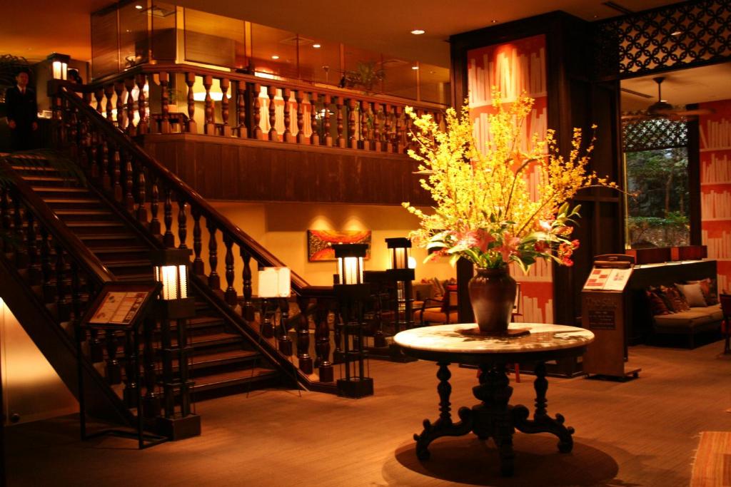 甲府市にある古名屋ホテルの階段と花瓶付きのテーブルが備わるお部屋