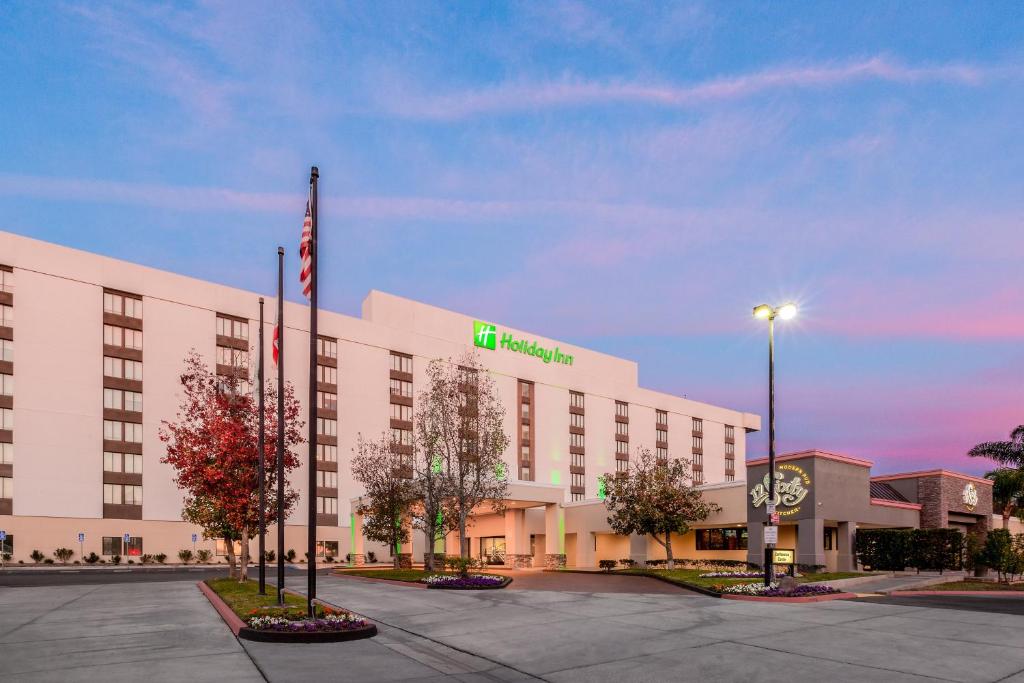 a hotel building with a green sign on it at Holiday Inn La Mirada Buena Park by IHG in La Mirada