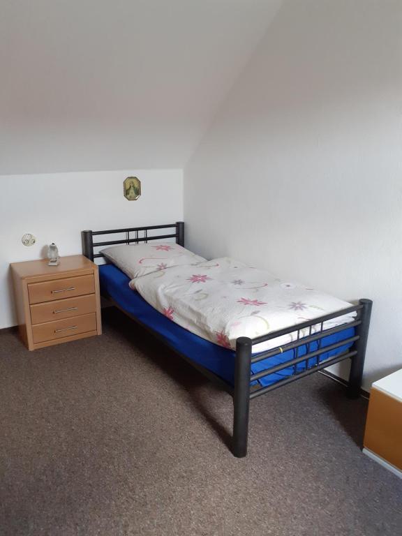 ein Schlafzimmer mit einem Bett und einer Holzkommode in der Unterkunft Ferienhaus Birkenallee in Papenburg