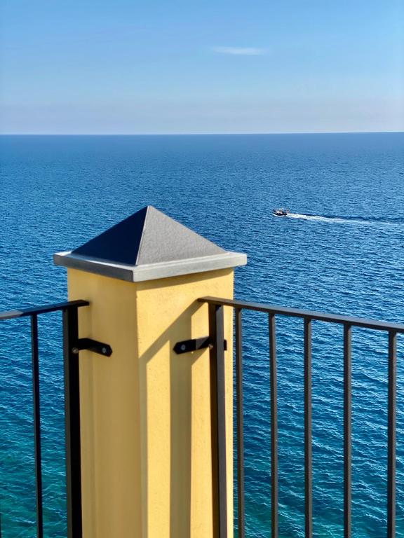a boat in the ocean with a lighthouse on a balcony at La Polena Camere Vernazza - Suite vista mare in Vernazza
