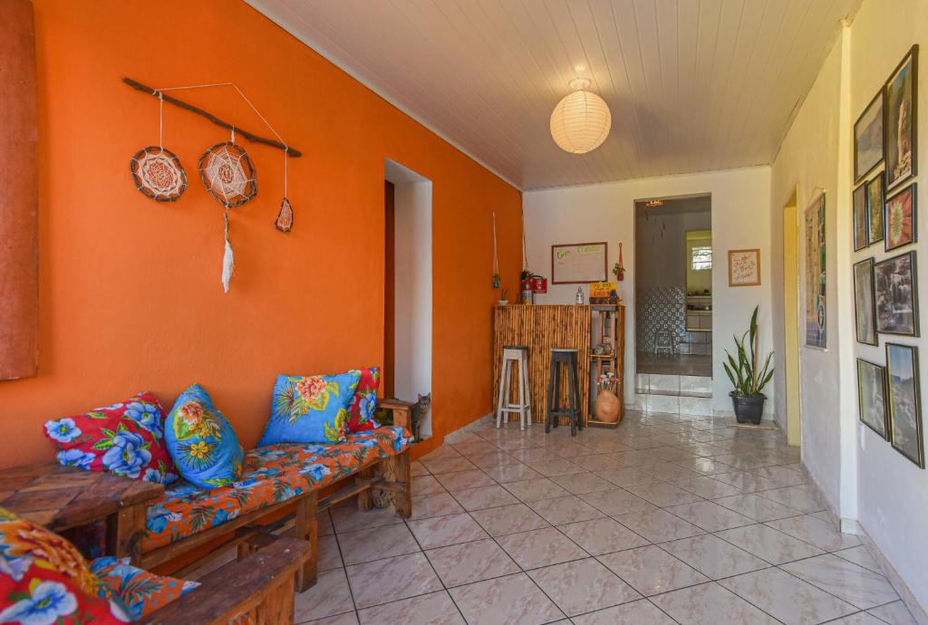 a living room with a couch and an orange wall at MangaMel Hostel in Lençóis
