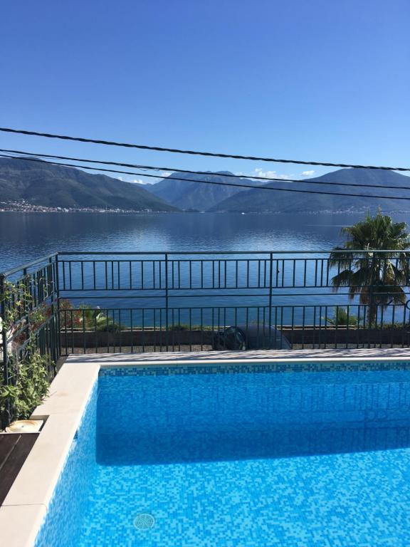 a swimming pool with a view of a body of water at Apartment Tri Kiparisa in Tivat