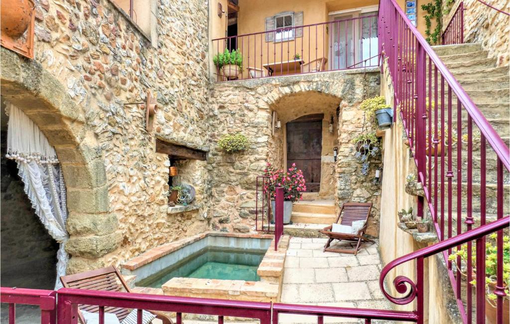 un edificio de piedra con piscina frente a un edificio en 2 Bedroom Awesome Home In La Bastide Dengras, en La Bastide-dʼEngras