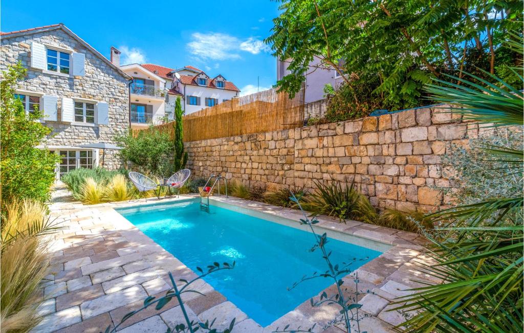 uma piscina num quintal ao lado de uma parede de tijolos em Stunning Home In Split With Outdoor Swimming Pool em Split