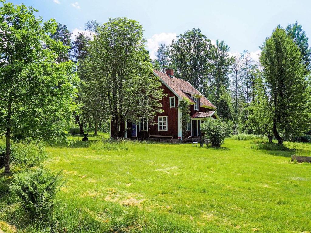 una vieja casa roja en un campo de césped verde en Holiday home ODENSBACKEN II, en Odensbacken