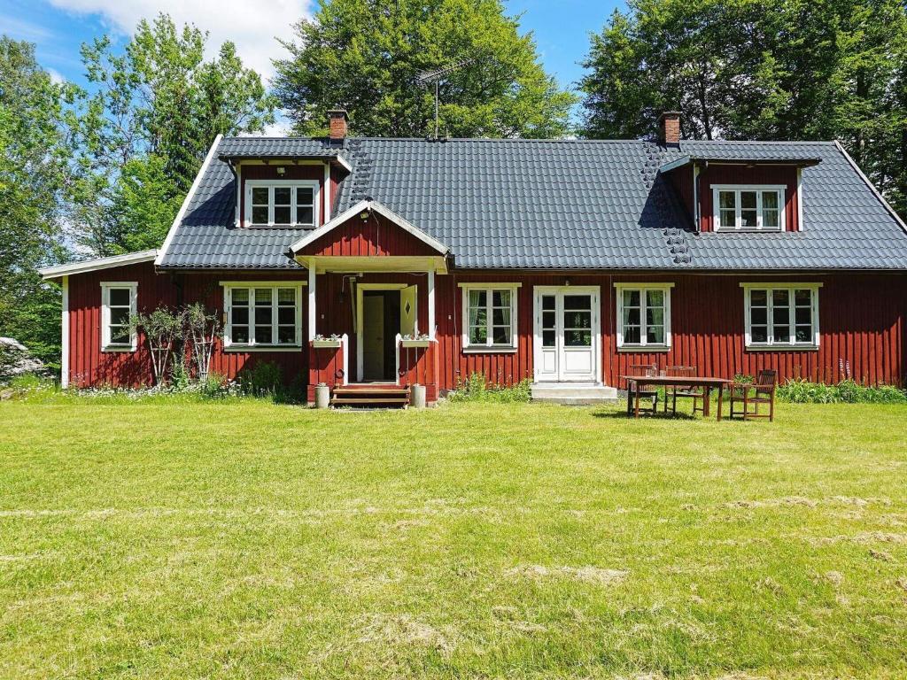 una casa roja con una mesa de picnic delante de ella en 7 person holiday home in R KE, en Röke