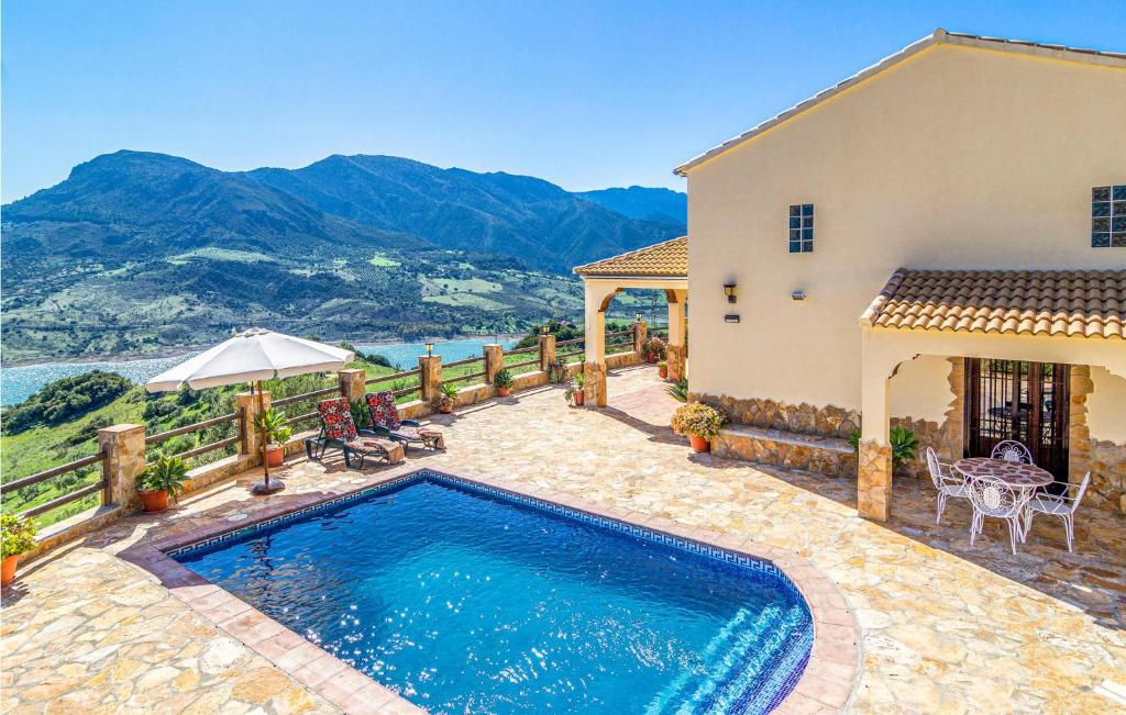 a villa with a swimming pool in front of a house at Nice Home In El Gastor With Outdoor Swimming Pool in El Gastor
