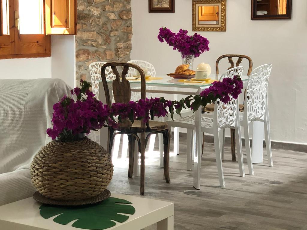 un comedor con una mesa con flores púrpuras. en Tutu llar us turistic, en Amposta