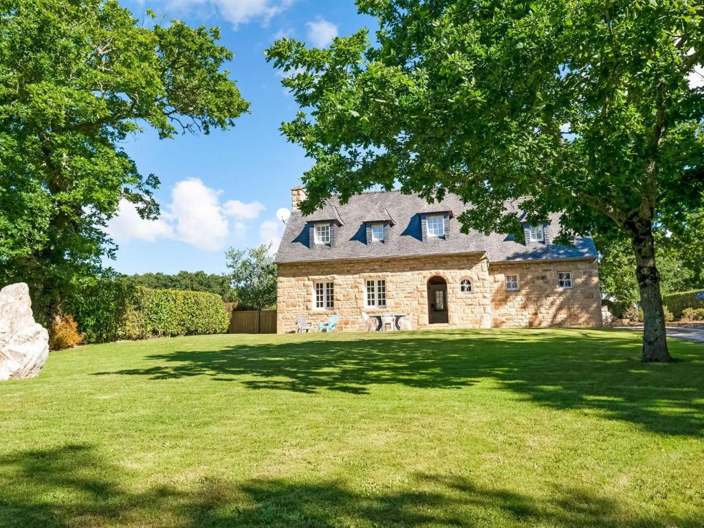 an old stone house on a green lawn at Quaint Holiday Home in Logonna Daoulas near Sea in Logonna-Daoulas