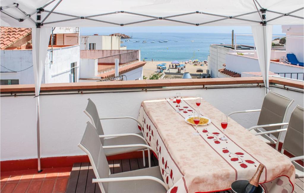 2 Bedroom Amazing Apartment In Tossa De Mar في توسا ذي مار: طاولة على شرفة مطلة على الشاطئ