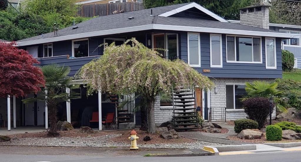 a blue house with a fire hydrant in front of it at Water View Home in Seattle