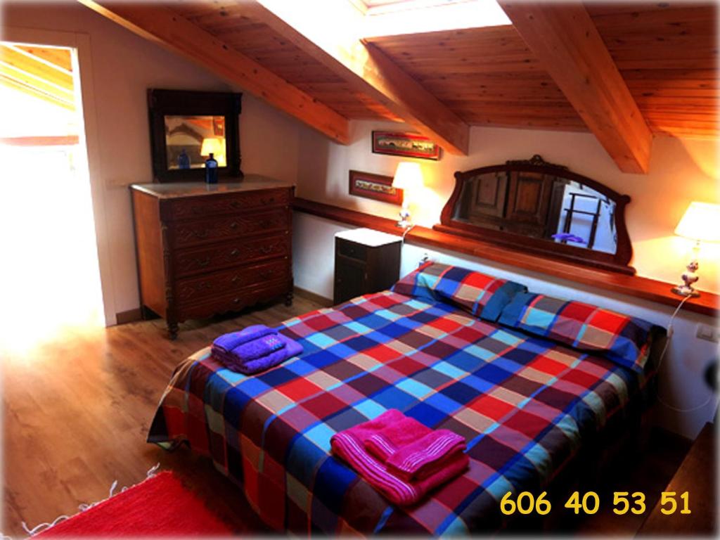 een slaapkamer met een bed en een dressoir in een kamer bij El Arcon in Simancas