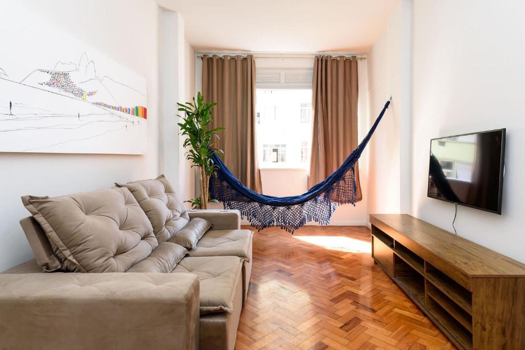 ein Wohnzimmer mit einem Sofa und einem Flachbild-TV in der Unterkunft 2 quartos em Copacabana c/ Vista Mar | PJ 135/808 in Rio de Janeiro
