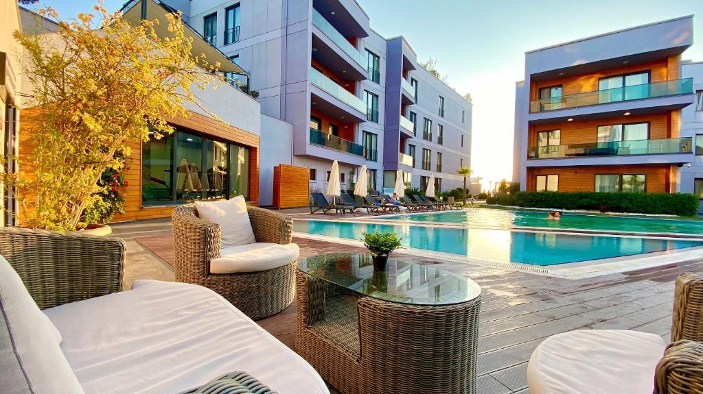 a patio with wicker chairs and a pool in a building at Green Hills Suites in Yalova