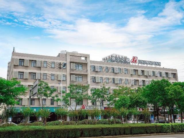 un grand bâtiment avec un panneau en haut dans l'établissement Jinjiang Inn East Siming Road in Higher Education Park , Ningbo, à Ningbo
