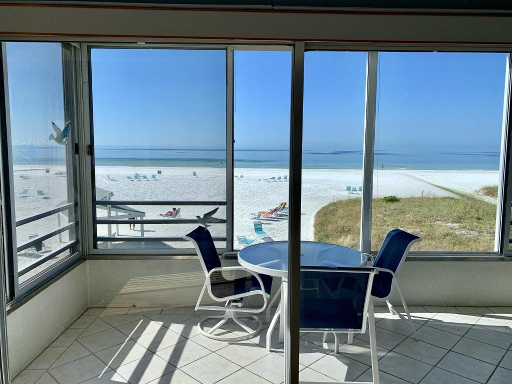 a table and chairs in a room with a view of the beach at Island House Beach Resort 3N in Siesta Key