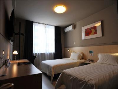 a hotel room with two beds and a window at Jinjiang Inn Xinchang Gushan Road Big Buddha Temple in Xinchang